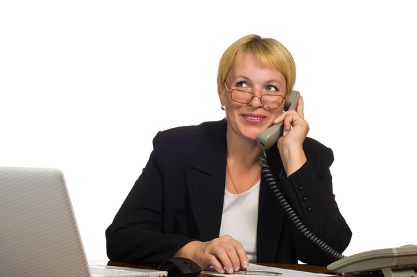 Mature businesswoman calling on the phone at her workplace - Zdjęcie, obraz