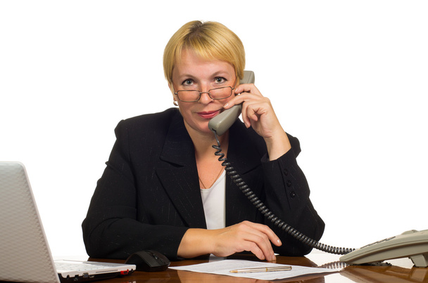 Mature businesswoman calling on the phone at her workplace - Foto, Bild
