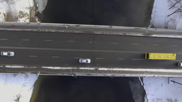 γέφυρα στην οποία κινούνται οχήματα θέα πάνω από τον ποταμό που ρέει στο κάτω μέρος, το χιονίζει - Πλάνα, βίντεο