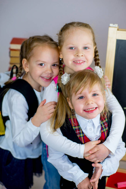 three young schoolgirls near the blackboard - Foto, Imagem