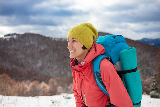Menina com mochila andando na neve nas montanhas
. - Foto, Imagem