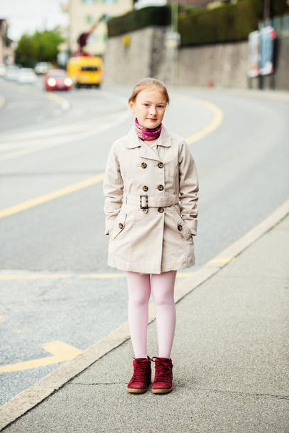 Πορτραίτου νεαρό παιδί κορίτσι φορώντας μπεζ trenchcoat και κόκκινες μπότες - Φωτογραφία, εικόνα