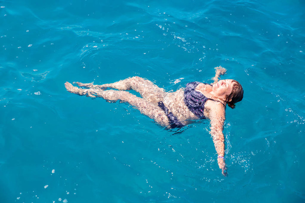 Femme âgée active nageant dans l'eau bleue
 - Photo, image