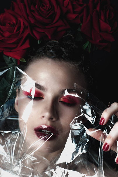 Beauty Fashion Model Woman face. Portrait with Red Rose flowers. Red Lips and Nails. Beautiful Brunette Woman with Luxury Makeup, perfect skin. Valentine. - Foto, immagini