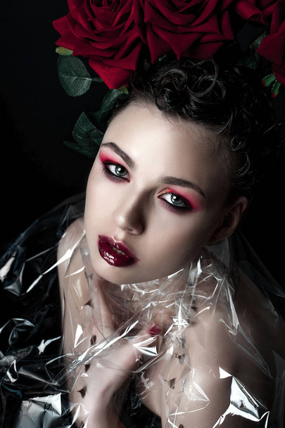 Schönheit Mode Modell Frau Gesicht. Porträt mit roten Rosenblüten. rote Lippen und Nägel. schöne brünette Frau mit Luxus-Make-up, perfekte Haut. Valentin. - Foto, Bild