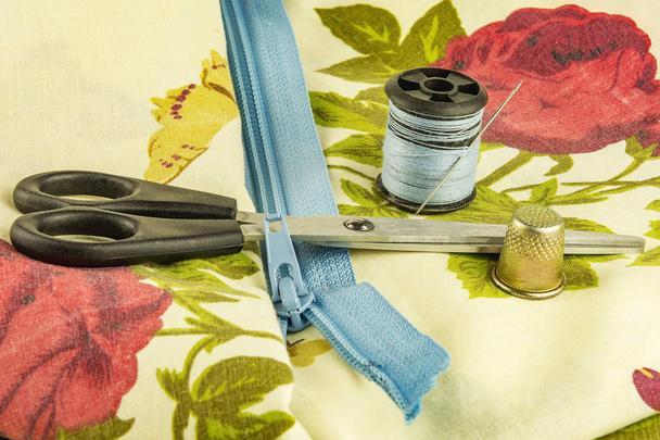Scissors, zipper lock with a spool of thread and a thimble - Foto, afbeelding