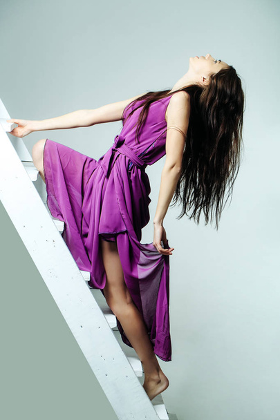 pretty woman on ladder in dress - Foto, Imagem