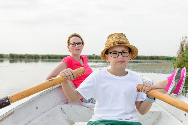 Lindo chico remando con la madre en el barco. activa feliz chico tener f
 - Foto, Imagen
