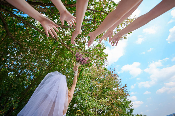 novia lanza el ramo de bodas para las mujeres jóvenes
 - Foto, Imagen