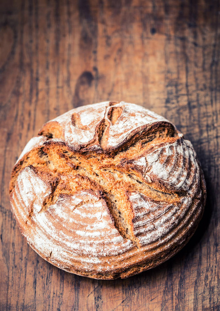 Bread.Fresh round crisp bread with caraway on wooden table - Fotografie, Obrázek
