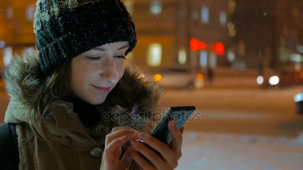 Mladá krásná žena pomocí smartphone ve městě v noci - Záběry, video