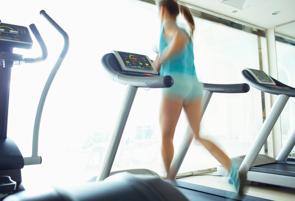 Woman running on treadmill in gym - Photo, Image