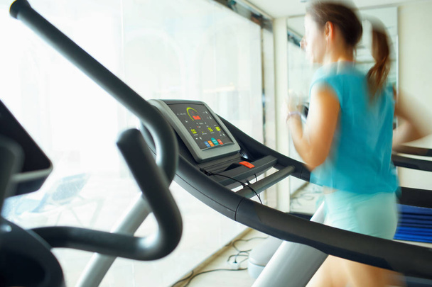 Woman running on treadmill in gym - Photo, Image