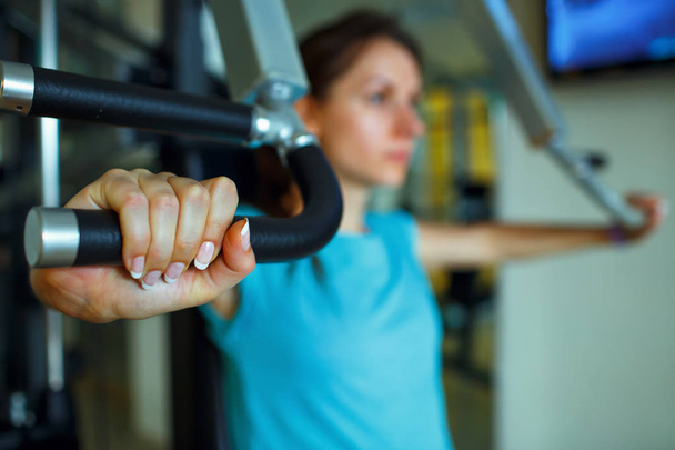 Femme athlétique travaille sur l'appareil d'entraînement dans la salle de gym
 - Photo, image