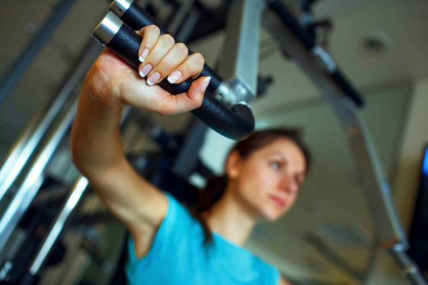 Athletic woman works out on training apparatus in gym - Foto, Imagen