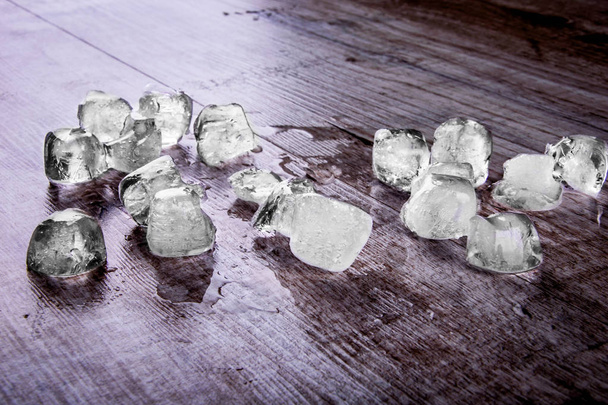 pieces of ice on a wooden background - Foto, afbeelding