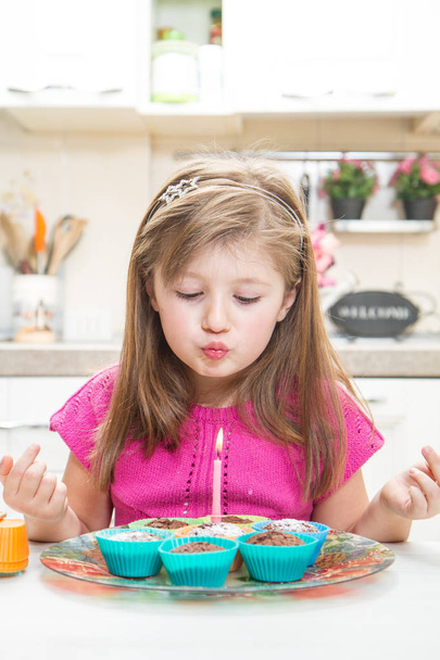 little girl blowing out candle  - Foto, afbeelding