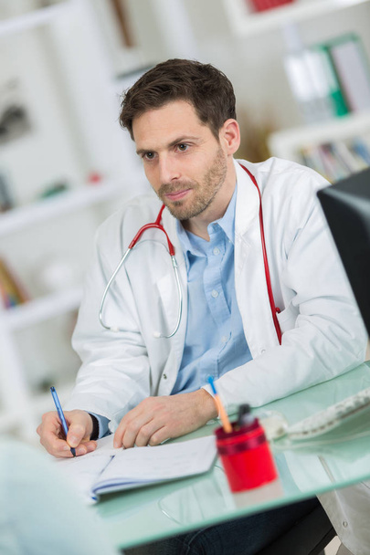 medical physician doctor listening to patient and taking notes - Фото, зображення