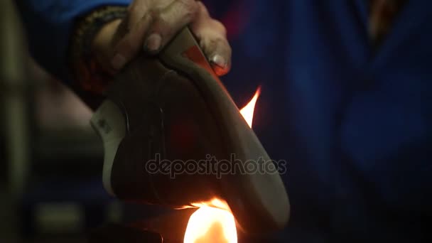 Zapatero haciendo zapatos. Trabajando con fuego en el taller de zapateros. Movimiento lento
. - Metraje, vídeo