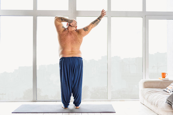 Male fatty exercising at home - Foto, afbeelding