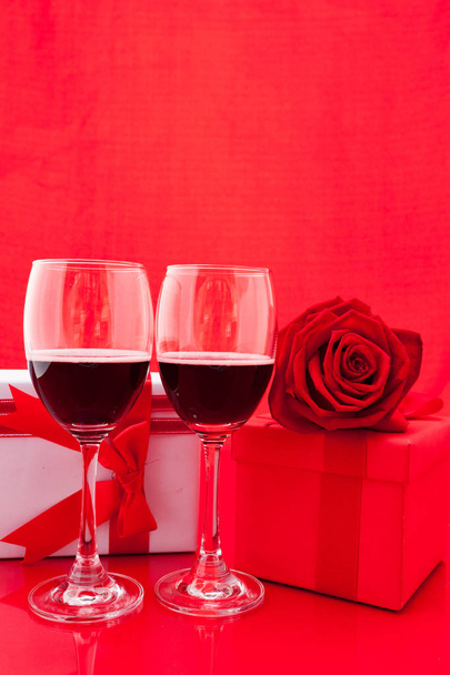 St Valentine's setting with present and red wine - Foto, afbeelding