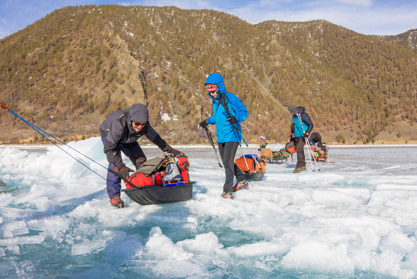 Lake Baikal, Russia - March 24, 2016: The men dragged the ice sl - 写真・画像