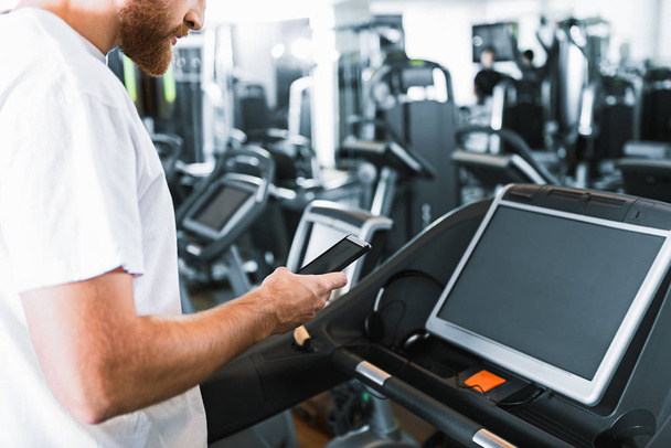 Bearded guy in gym at treadmill - Фото, изображение