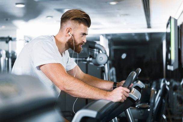 Concentrated sporty man in gymnasium - Foto, Bild