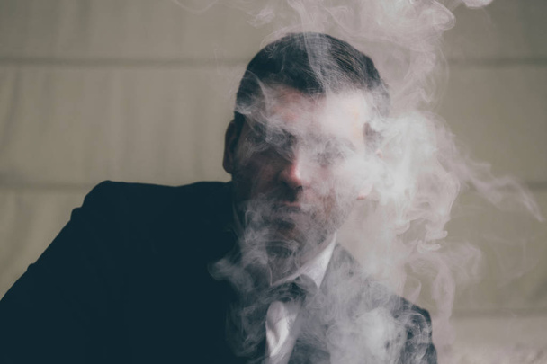 Mysterious businessman in smoke - Foto, Imagen