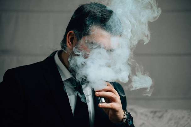 businessman smoking electronic cigarette - Fotó, kép