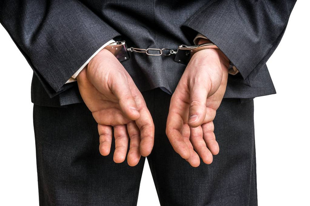 Empresário preso algemado com as mãos atrás das costas
 - Foto, Imagem