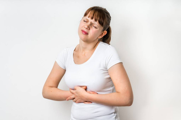 Femme avec des douleurs à l'estomac tient son ventre douloureux
 - Photo, image