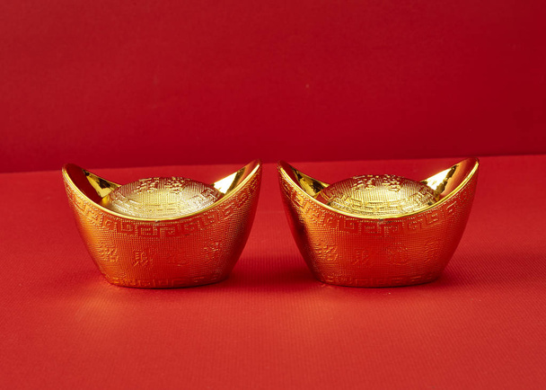 lingote de ouro em um fundo vermelho
 - Foto, Imagem