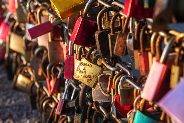 Love pedlocks in red and gold locked at a bridge at a tourists place, symbol for eternal love - Foto, Imagem