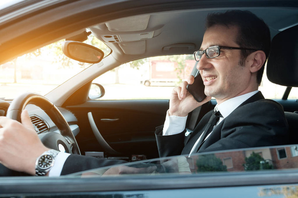 Manager telefoniert im Auto sitzend - Foto, Bild