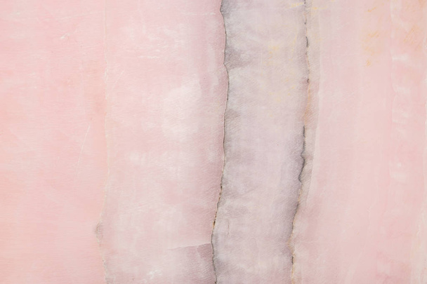 Könnyű szeletek márvány onyx. Vízszintes kép. Meleg rózsaszín színek. Gyönyörű közelről háttér - Fotó, kép