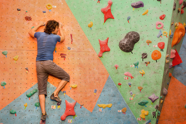 joven escalando roca artificial en el interior, concepto de deporte moderno
 - Foto, imagen
