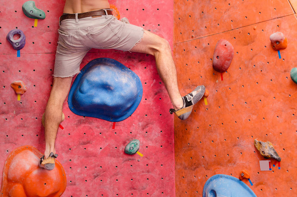 treino de escalador masculino na parede do ginásio de pedregulho, close-up de músculos da perna com sapatos
 - Foto, Imagem