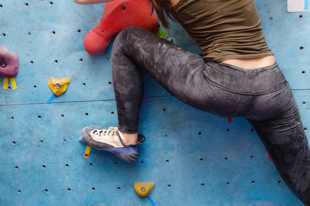 Foot of female climber on artificial boulder. Close-up view of professional shoe - Photo, Image