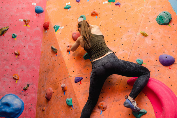 atrakcyjne młody sport zawodowy wspinacz kobieta o szkolenia w sali gimnastycznej na sztucznej ścianie - Zdjęcie, obraz