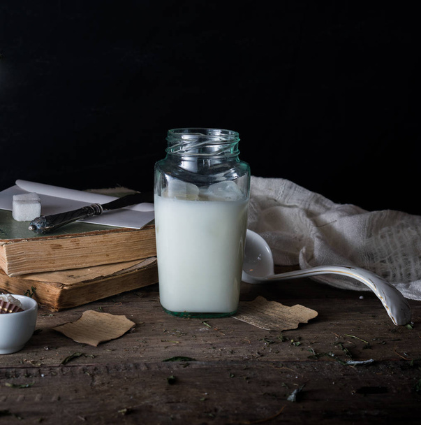 rustic breakfast. still life, vintage. the book chrysanthemums, the milk bank. black background - Φωτογραφία, εικόνα