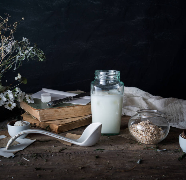 rustic breakfast. still life, vintage. the book chrysanthemums, the milk bank. black background. space for text - 写真・画像