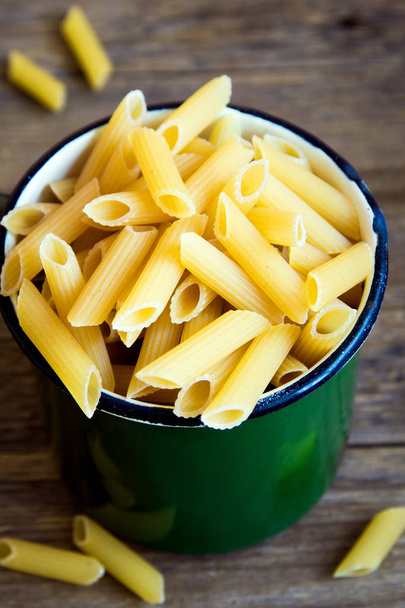 Uncooked raw italian penne pasta in metal mug - healthy ingredient for cooking - Fotoğraf, Görsel