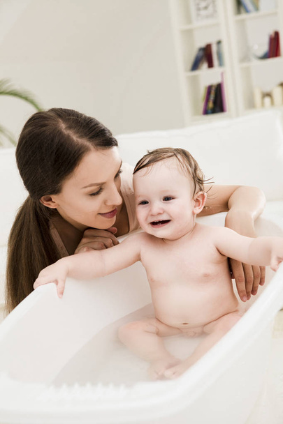 Mother Bathing Her Baby - Photo, image