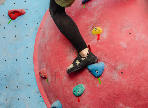 Láb cipő női mászó a mesterséges boulder fal-on tornaterem - Fotó, kép