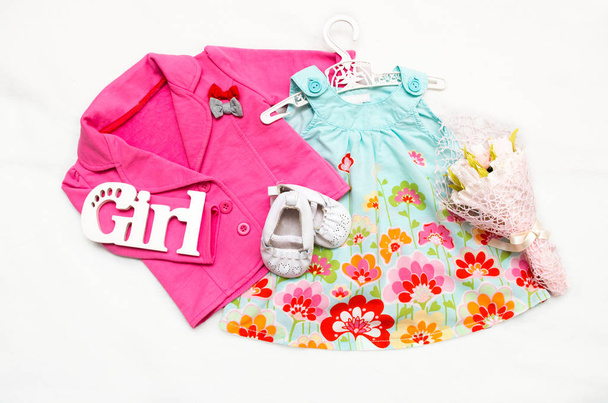 Набор одежды для маленькой девочки. Розовая куртка, платье, ботинки
. - Фото, изображение