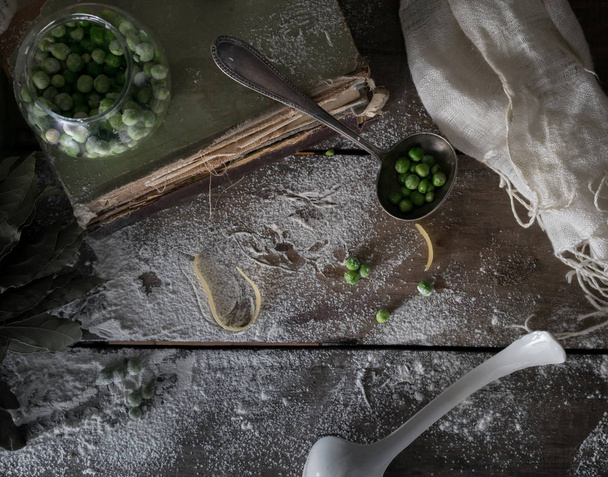 rustic still life, vintage. green peas, old books, flour on a wooden table. top view - Foto, Bild