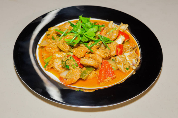 gebratene Meeresfrüchte mit Curry-Pulver auf Teller - Foto, Bild