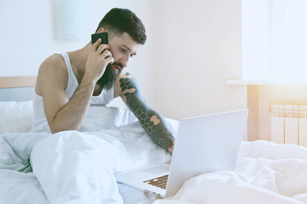 Bearded man with laptop and phone - Foto, imagen