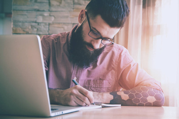 Bearded man working with laptop  - Zdjęcie, obraz